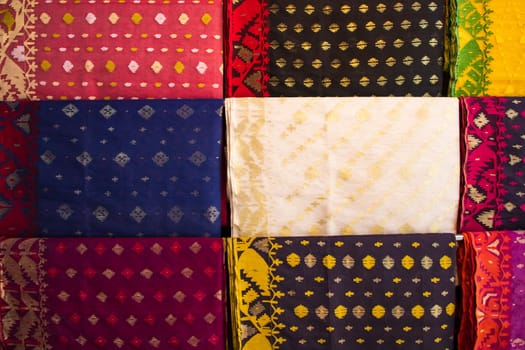 Bangladeshi Women,s Traditional Colorful Jamdani saree hanging in the retail Showrooms. Colorful Jamdani Saree Texture Background