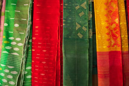 Bangladeshi Women,s Traditional Colorful Jamdani saree hanging in the retail Showrooms. Colorful Jamdani Saree Texture Background