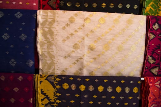 Bangladeshi Women,s Traditional Colorful Jamdani saree hanging in the retail Showrooms. Colorful Jamdani Saree Texture Background