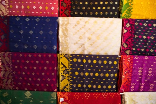 Bangladeshi Women,s Traditional Colorful Jamdani saree hanging in the retail Showrooms. Colorful Jamdani Saree Texture Background