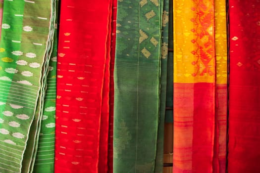 Bangladeshi Women,s Traditional Colorful Jamdani saree hanging in the retail Showrooms. Colorful Jamdani Saree Texture Background