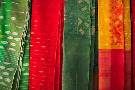Bangladeshi Women,s Traditional Colorful Jamdani saree hanging in the retail Showrooms. Colorful Jamdani Saree Texture Background