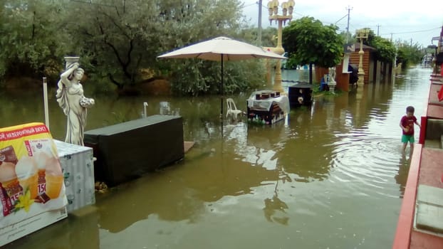 Anapa, Russia August 13 2021 Flooding caused by heavy rains and downpours. Consequences of a typhoon, cyclone or hurricane. Shopping street flooded with dirty water. Wet belongings and beach walkways
