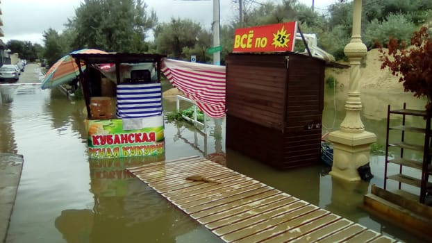 Anapa, Russia August 13 2021 Flooding caused by heavy rains and downpours. Consequences of a typhoon, cyclone or hurricane. Shopping street flooded with dirty water. Wet belongings and beach walkways