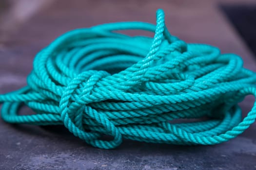 close up of a green rope on a fishing boat in the harbor