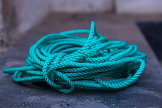 close up of a green rope on a fishing boat in the harbor
