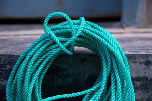 Close-up of a green rope on the deck of a boat.