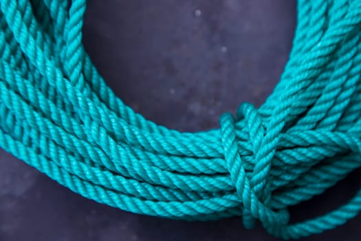 Close-up of green rope on dark background. Copy space for text.