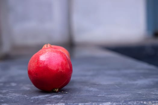 Ripe red pomegranate on a gray background. Copy space.