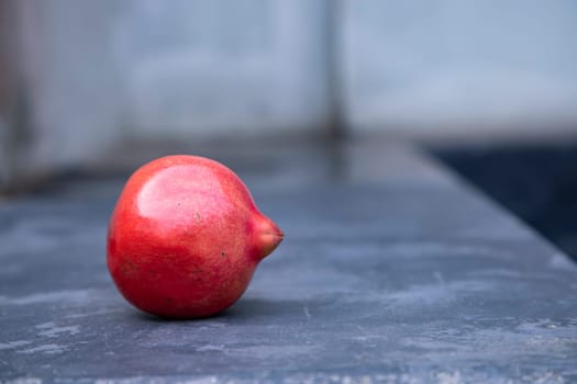 Ripe red pomegranate on a stone table. Close up