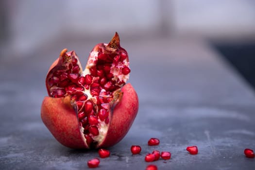 Ripe pomegranate fruit on a dark concrete background.