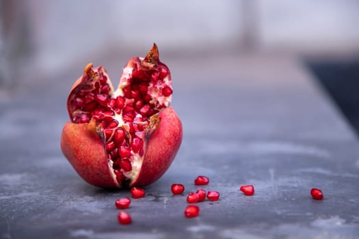Ripe pomegranate fruit with seeds on a dark background