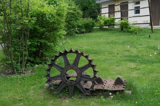 Rusty fragment (link) tracks and the drive wheel (gear), military tank, lying on the grass