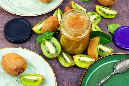 Delicious kiwi jam in a glass jar. Top view, copy space.