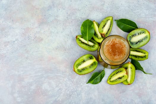 Delicious kiwi jam in a glass jar. Top view, copy space.