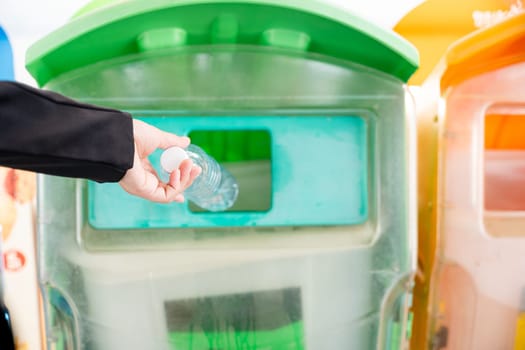 World Environment Day concept. Business woman throwing empty plastic bottle water into recycle garbage trash or bin, Waste management environmental recycling concept