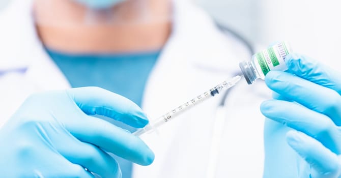 COVID-19 vaccine, Doctor man pull syringe on liquid bottle COVID-19 (coronavirus) vaccine for injection at hospital, nurse holding medicine and drug concept