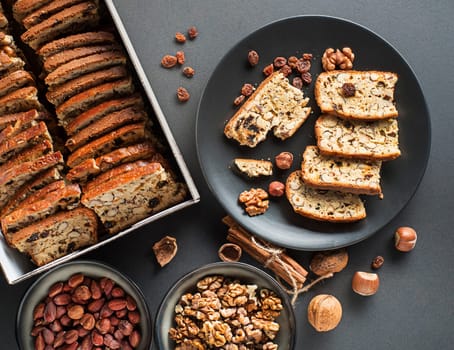 Tasty traditional homemade biscotti biscuits on black table background. Delicious cantucci cookies with nuts and raisin.