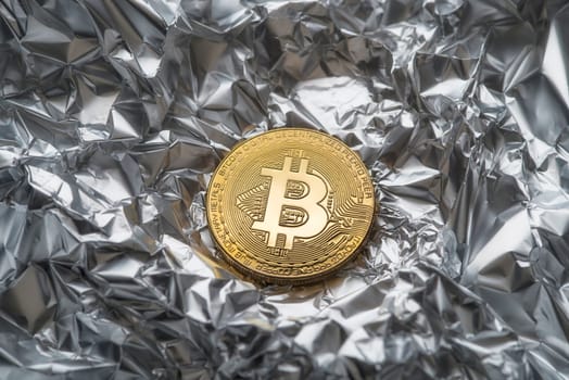 Golden coin with bitcoin symbol close up. Bitcoin and cryptocurrency investing concept. Bitcoin cryptocurrency coin on silver background. Trading on the cryptocurrency exchange