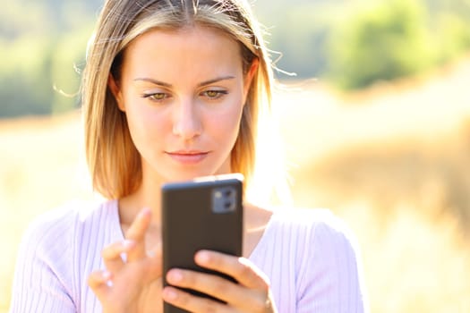 Front view portrait of a teen using cell phone in nature