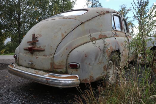 Abandoned vintage car rear view, low angle