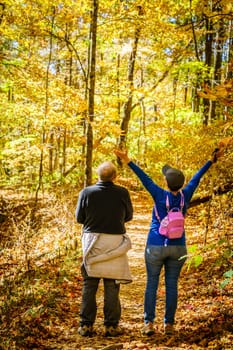 Senior couple is hiking in the woods in North Carolina in fall
