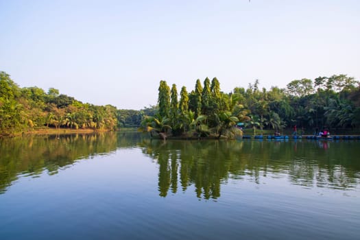 Natural landscape view Reflection of trees in the lake water against blue sky