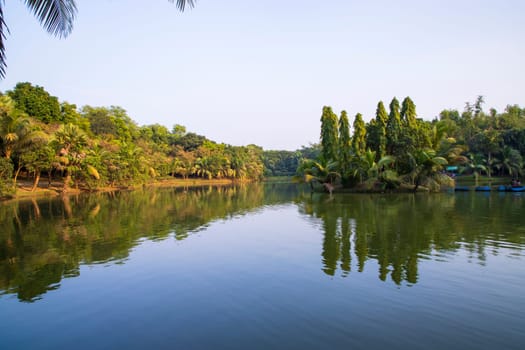 Natural landscape view Reflection of trees in the lake water against blue sky
