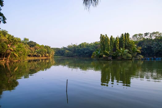Natural landscape view Reflection of trees in the lake water against blue sky
