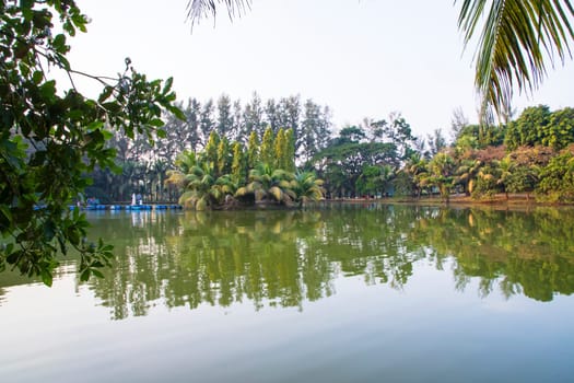 Natural landscape view Reflection of trees in the lake water against blue sky