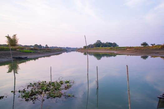 Arial View Canal with green grass and vegetation reflected in the water nearby Padma river in Bangladesh