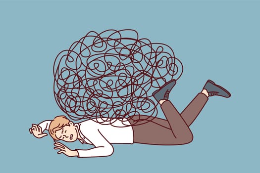 Depressed businessman lies on ground face down under heavy load of tangled lines. Guy in office clothes is tired of fighting because of stress at work and frequent overload