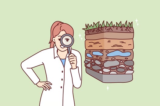 Woman scientist with magnifying glass is engaged in geology in search of deposits of valuable resources. Girl ecologist in white coat conducts examination of soil pollution