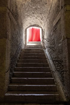 Old corridor with red curtain at the end. Concept for mystery, gothic, escape, hope