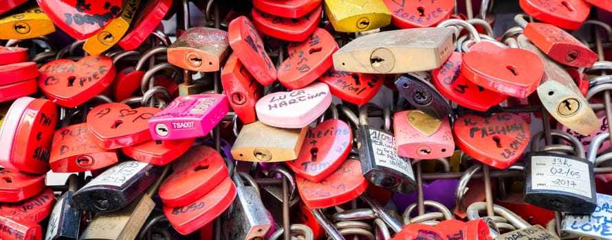 Verona, Italy - June 2022: background of heart-shaped locks on a wall, symbol of love forever