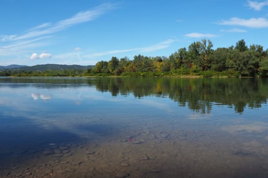 Drina river near the town of Banja Koviljaca, Serbia, view of the coast of Bosnia and Herzegovina. Rybnik on the Drina. The flow of water, blue sky, greenery on the opposite side of the river