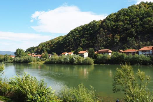 Mali Zvornik, Serbia, September 29, 2022. Drina river near Banja Koviljaca, view of the coast of Serbia from BiH. The flow of water, greenery on the opposite bank of the river. Residential houses