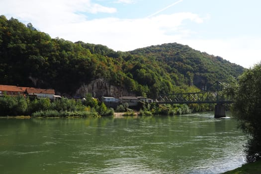 Mali Zvornik, Serbia, September 29, 2022. Drina river near Banja Koviljaca, view of the coast of Serbia from BiH. The flow of water, greenery on the opposite bank of the river. Residential houses