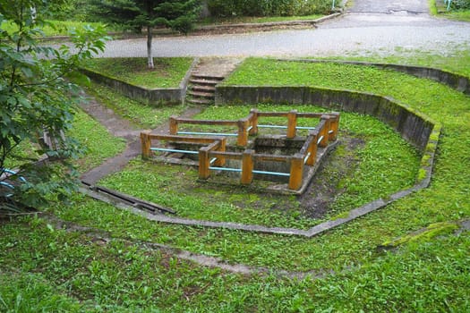 Banja Koviljaca, Loznica, Serbia. Mount Guchevo, park and forest. Source of mineral sulfuric and ferruginous water Rakina Chesma Cesma. A spring near the road to Guchevo. Concrete fence and stairs