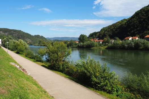 Mali Zvornik, Serbia, September 29, 2022. Drina river near Banja Koviljaca, view of the coast of Serbia from BiH. The flow of water, greenery on the opposite bank of the river. Residential houses