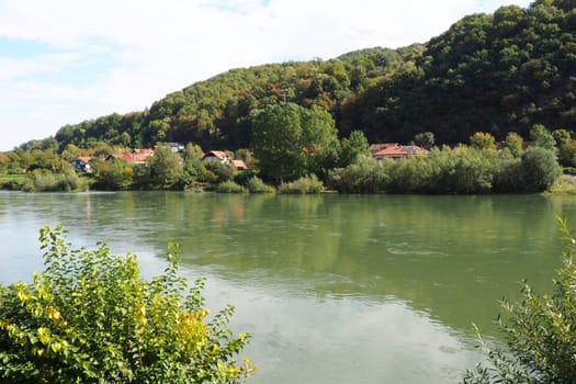 Mali Zvornik, Serbia, September 29, 2022. Drina river near Banja Koviljaca, view of the coast of Serbia from BiH. The flow of water, greenery on the opposite bank of the river. Residential houses