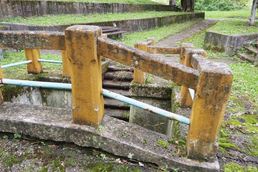 Banja Koviljaca, Loznica, Serbia. Mount Guchevo, park and forest. Source of mineral sulfuric and ferruginous water Rakina Chesma Cesma. A spring near the road to Guchevo. Concrete fence and stairs