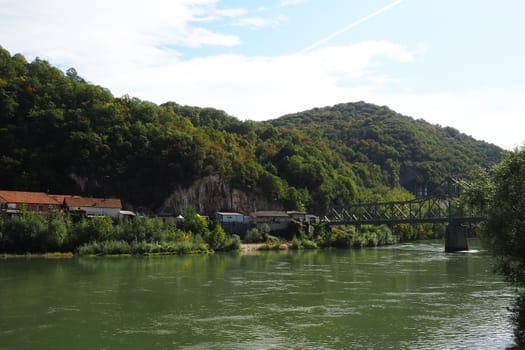 Mali Zvornik, Serbia, September 29, 2022. Drina river near Banja Koviljaca, view of the coast of Serbia from BiH. The flow of water, greenery on the opposite bank of the river. Residential houses