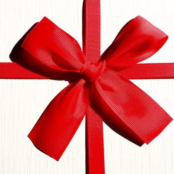 White gift box with red ribbon bow isolated on white background.