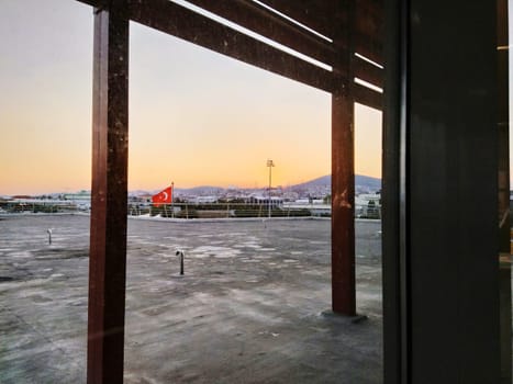 Istanbul Turkiye, Sabiha Gokcen Airport Uluslararasi Havalimani 04.08.2022 view from window on the city of Istanbul through the glass. Turkish flag, hydrants or ventilation. Sunset over the mountains