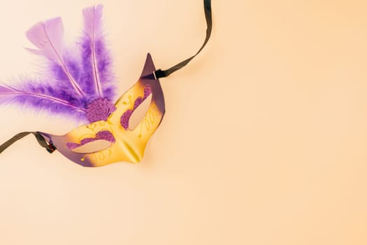 Happy Purim carnival decoration. Top view venetian ball mask with purple feather on pastel background, Jewish Purim and Mardi Gras in Hebrew, holiday background banner design, Masquerade party