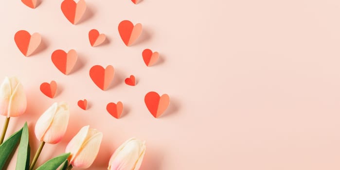 Happy Valentines Day background. Top view flat lay of red paper hearts shape and pink tulips flower on pink background with copy space