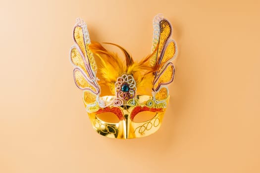 Happy Purim carnival decoration. Golden venetian ball mask, carnival mask isolated on pastel background, Purim or Mardi Gras in Hebrew, Masquerade party event