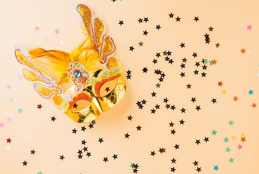 Happy Purim carnival decoration. Golden venetian ball mask, carnival mask isolated on pastel background, Purim or Mardi Gras in Hebrew, Masquerade party event