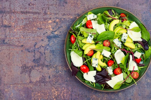 Salad with fresh lettuce, greens, avocado, tomatoes and cheeses. Space for text.